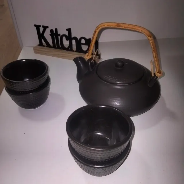 Tetera y vasos negros con asa de bambú