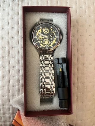 Reloj de pulsera plateado con detalles dorados
