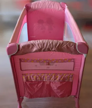 Cuna de viaje rosa impecable.