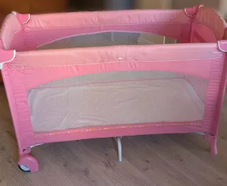 Cuna de viaje rosa impecable.