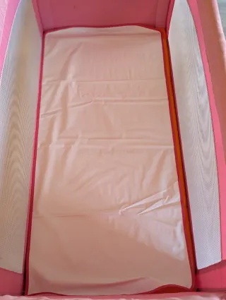 Cuna de viaje rosa impecable.