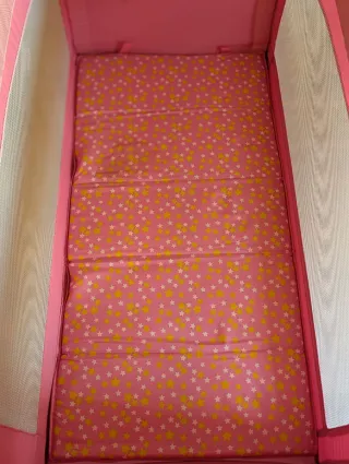 Cuna de viaje rosa impecable.