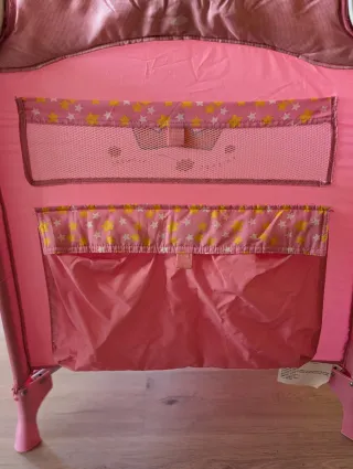 Cuna de viaje rosa impecable.