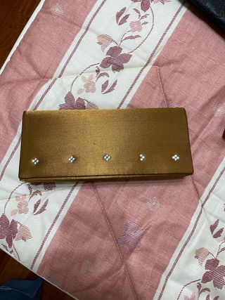 Bolso de mano dorado con pedrería