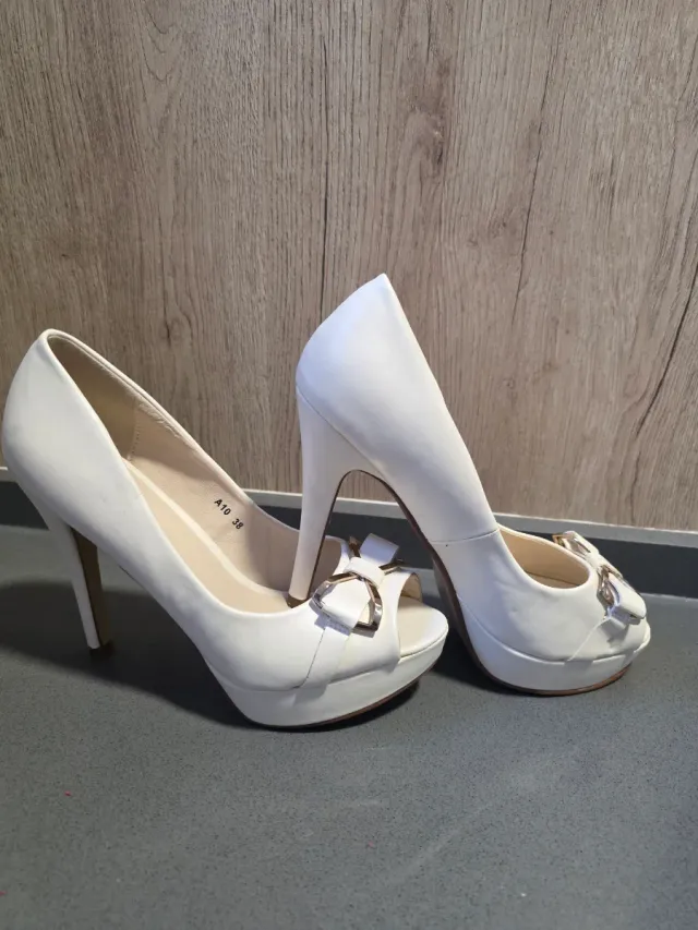 Zapatos de tacón blancos con lazo dorado