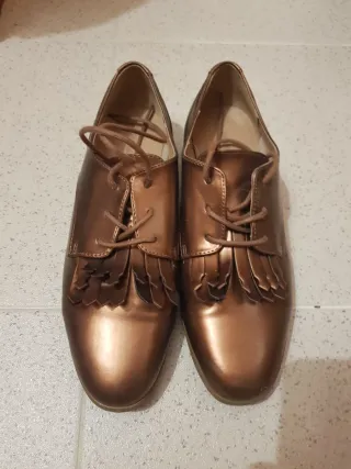 Sapatos rasos dourados com franjas