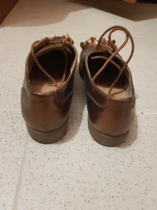 Sapatos rasos dourados com franjas