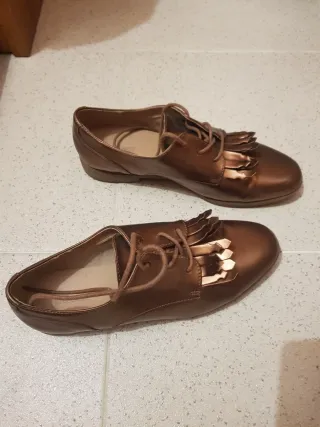 Sapatos rasos dourados com franjas