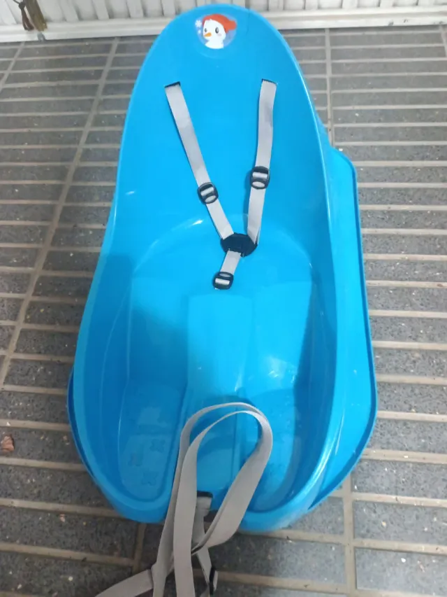 Trineo infantil azul con arnés.