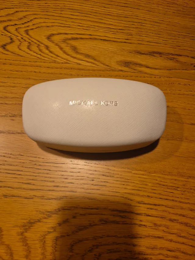 Funda de gafas Michael Kors blanca.