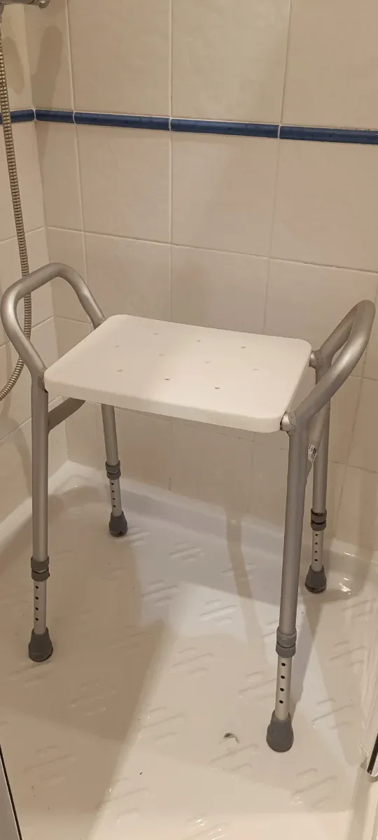 Silla de ducha plateada y blanca