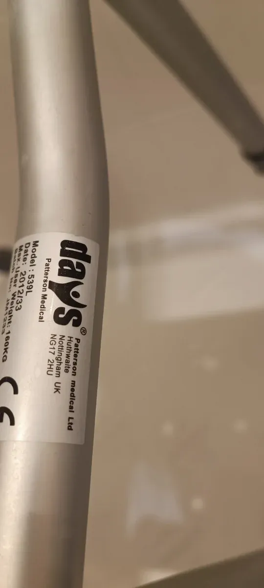 Silla de ducha plateada y blanca