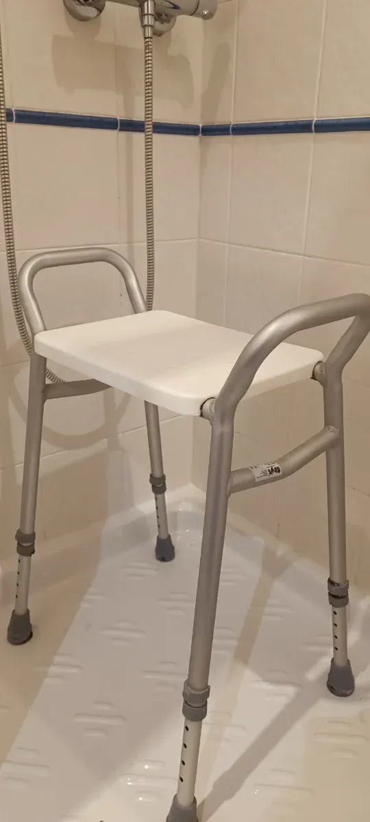 Silla de ducha plateada y blanca