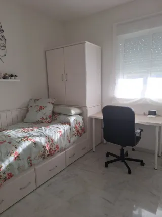 Dormitorio juvenil compacto con mesa y silla.