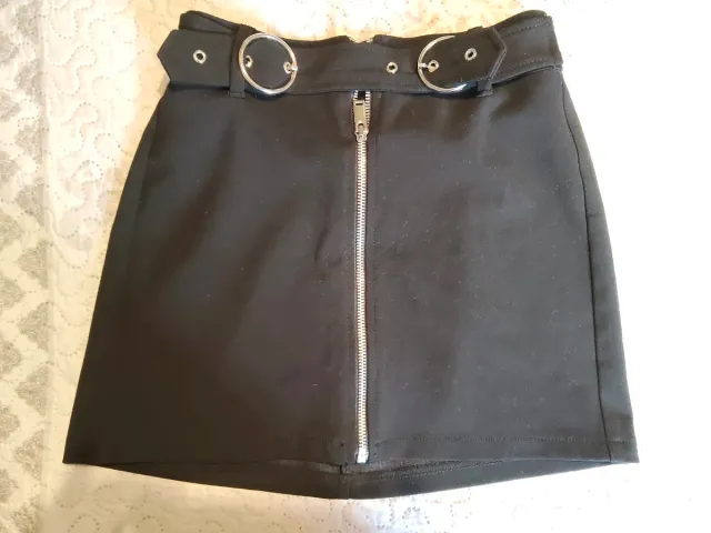 Falda negra ajustada con cremallera y cinturón.