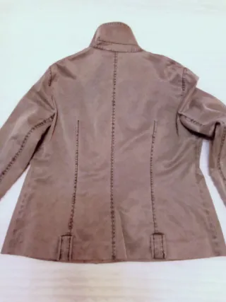 Chaqueta gris elástica con cremallera lateral.