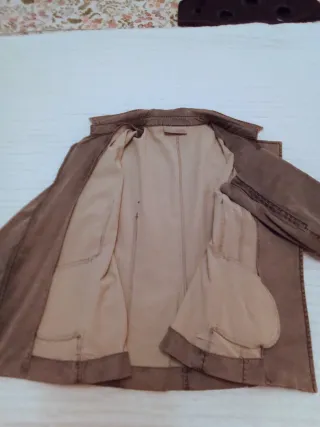 Chaqueta gris elástica con cremallera lateral.