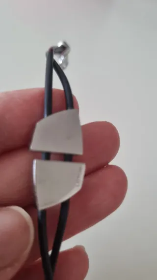 Pulsera de goma negra con detalles plateados