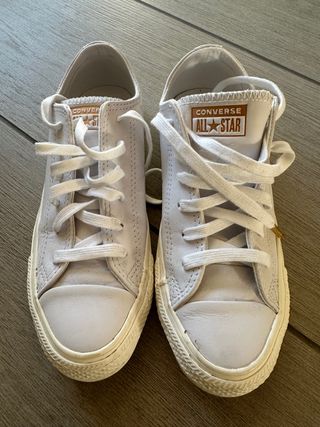 Zapatos Converse blancos y dorados
