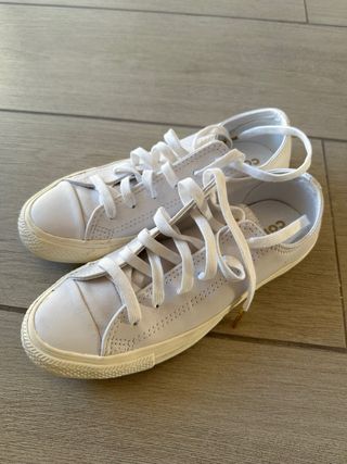 Zapatos Converse blancos y dorados