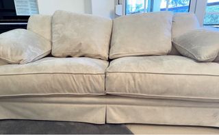 Sofá de tela beige con relleno de plumas de oca