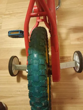 Bicicleta infantil roja con ruedines