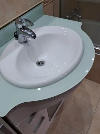 Mueble de baño blanco y cristal, con griferia.