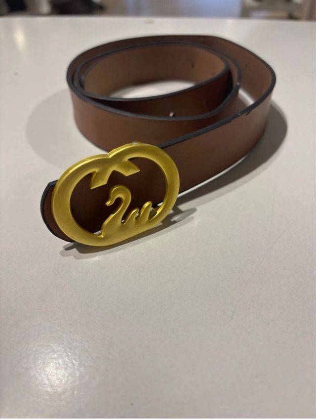 Cinturón marrón con hebilla dorada de cisne