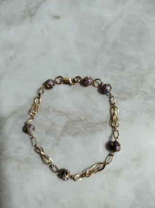 Pulsera dorada con cuentas moradas
