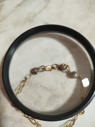 Pulsera dorada con cuentas moradas