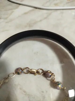 Pulsera dorada con cuentas moradas