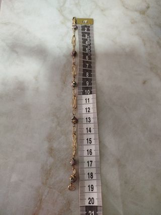 Pulsera dorada con cuentas moradas