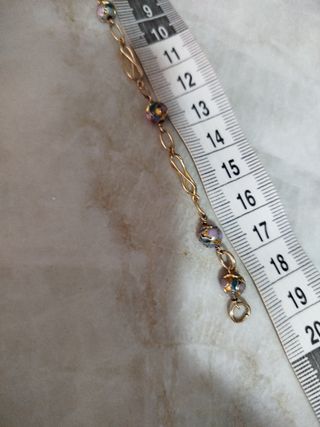 Pulsera dorada con cuentas moradas