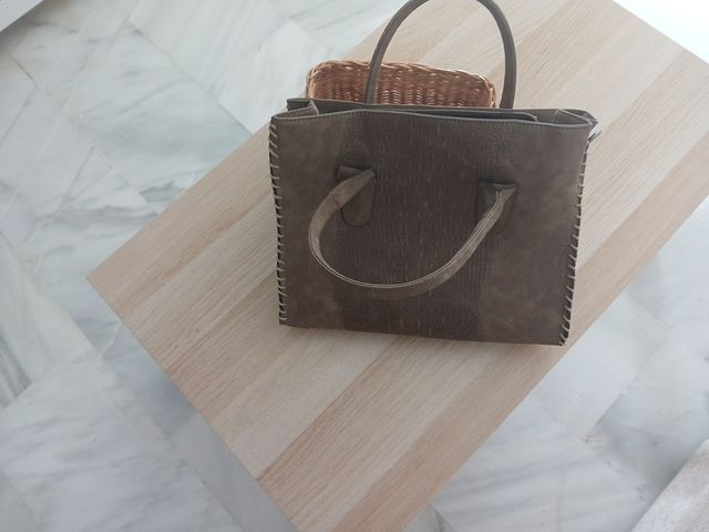 Bolso de mano marrón con su funda.