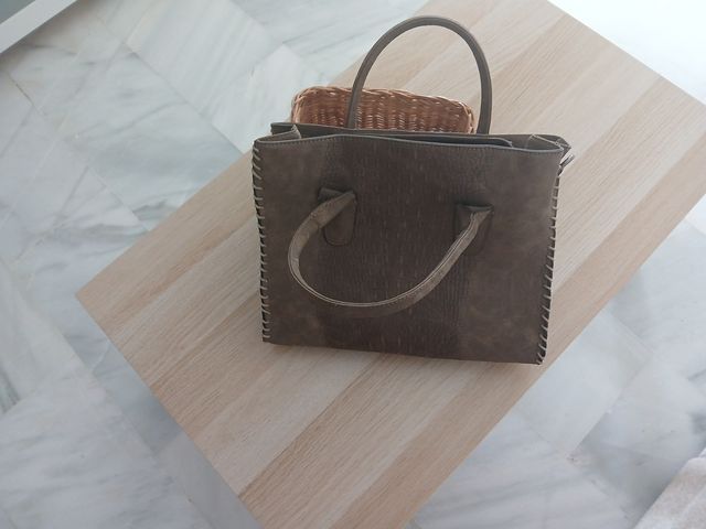 Bolso de mano marrón con su funda.