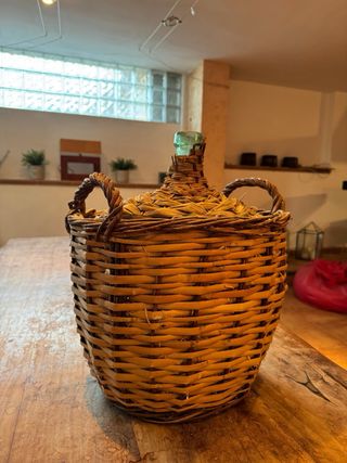 Botella antigua de vidrio con cestería