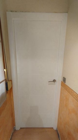 Puerta blanca con manilla y mirilla