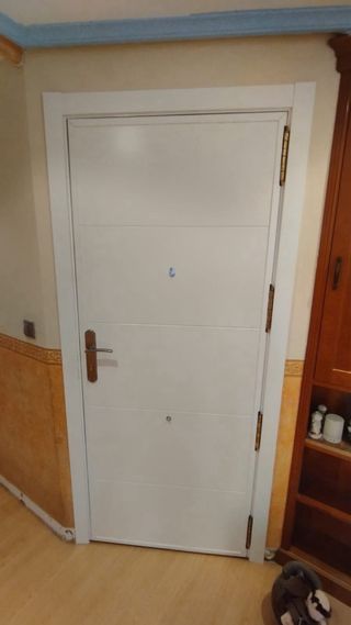 Puerta blanca con manilla y mirilla