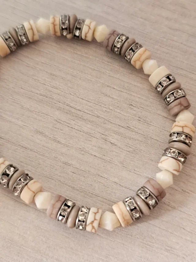 Pulsera de cuentas beige y grises con detalles