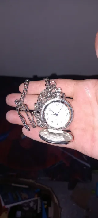 Reloj de bolsillo plateado con cadena