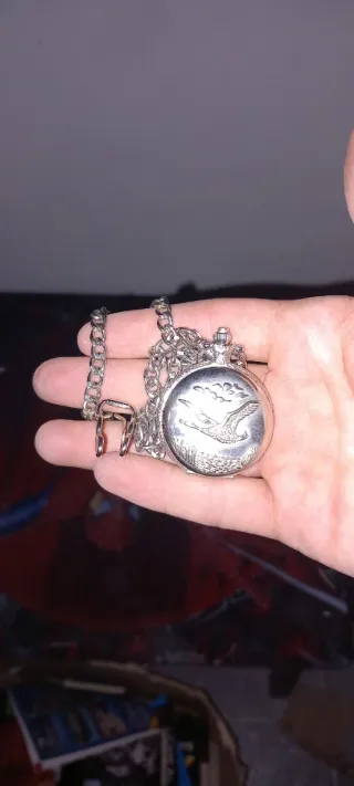 Reloj de bolsillo plateado con cadena