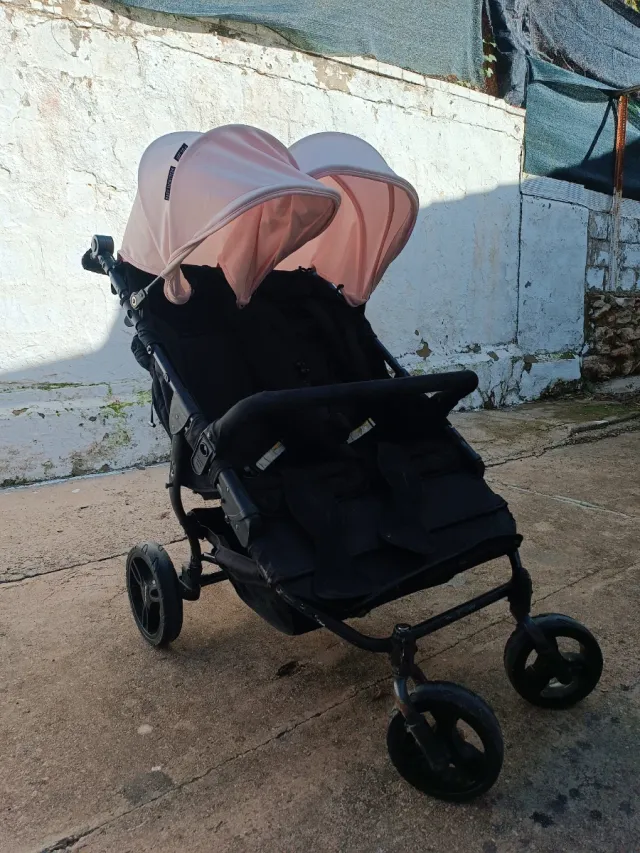 Carro gemelar negro con capotas rosas