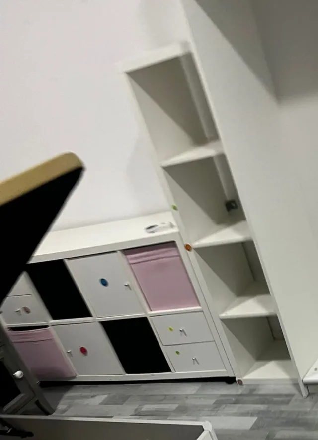 Mueble blanco y rosa con cajones y estantería