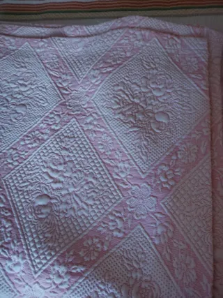 Colcha rosa e branca com padrão floral