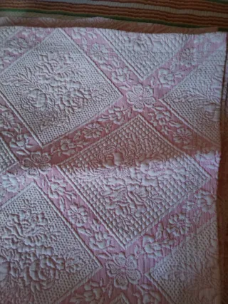 Colcha rosa e branca com padrão floral