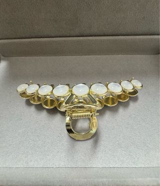 Mola de cabelo dourada com pedras brancas