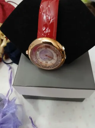 Reloj BKONE dorado y rojo.Es reloj de señora