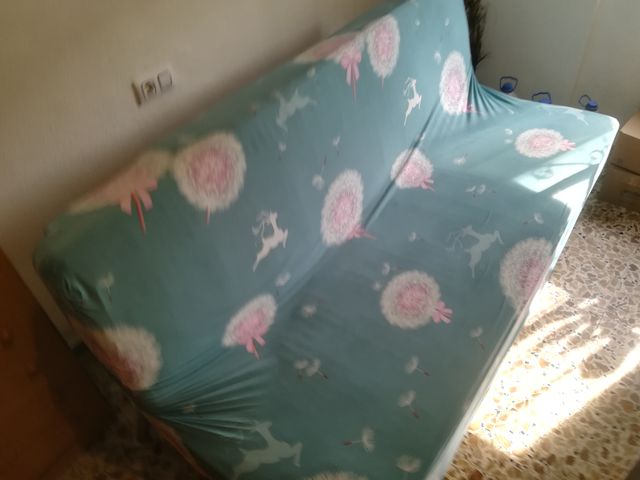 Sofá cama verde con estampado de dalias
