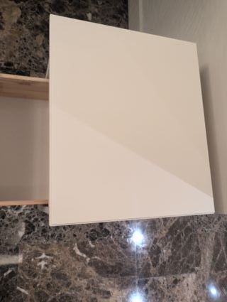 Mesita de noche blanca de madera con un cajón.