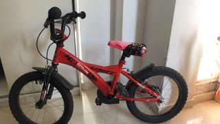 Bicicleta infantil roja con casco azul